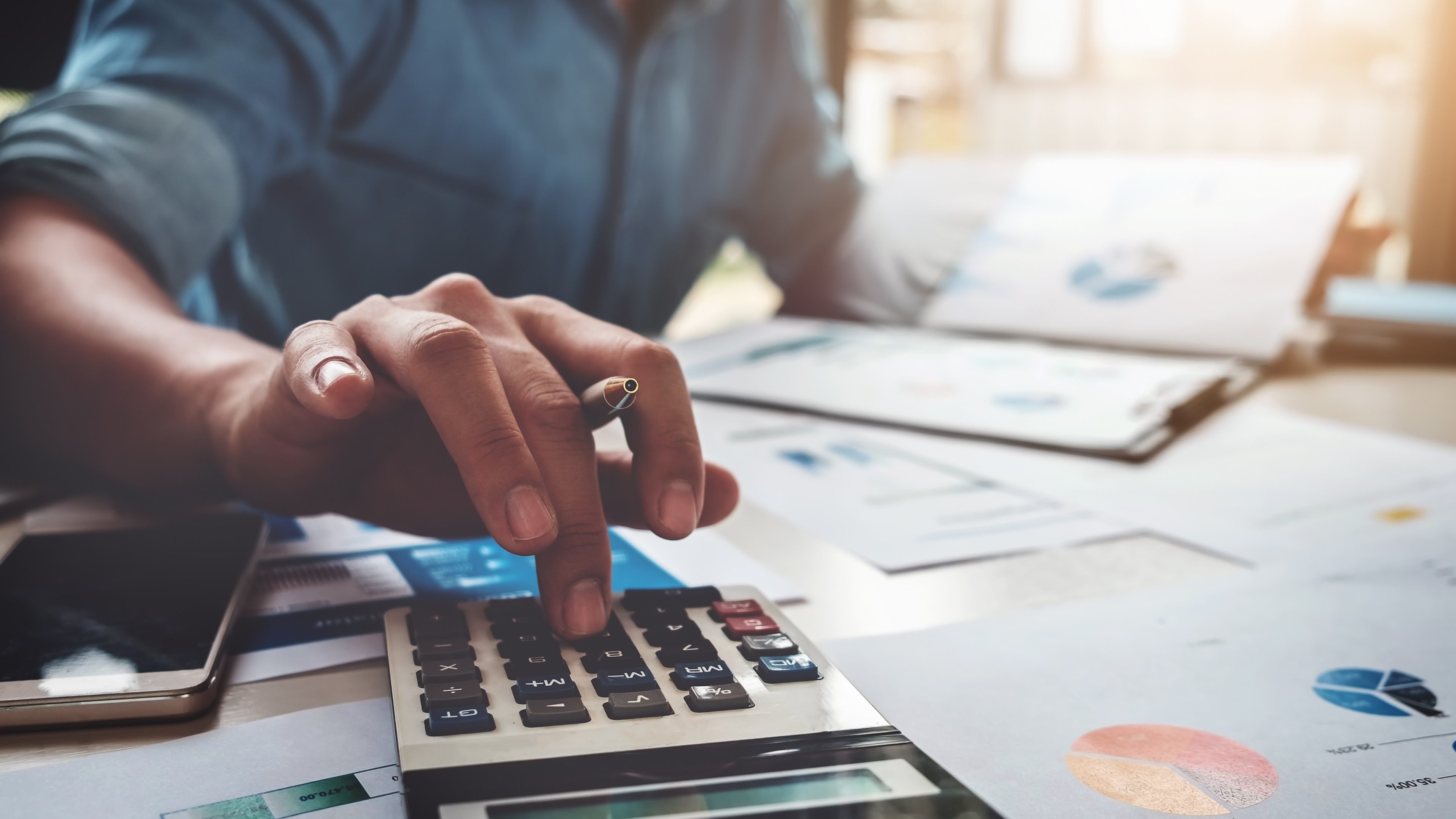 Business accounting concept, Business man using calculator with computer laptop, budget and loan paper in office. 